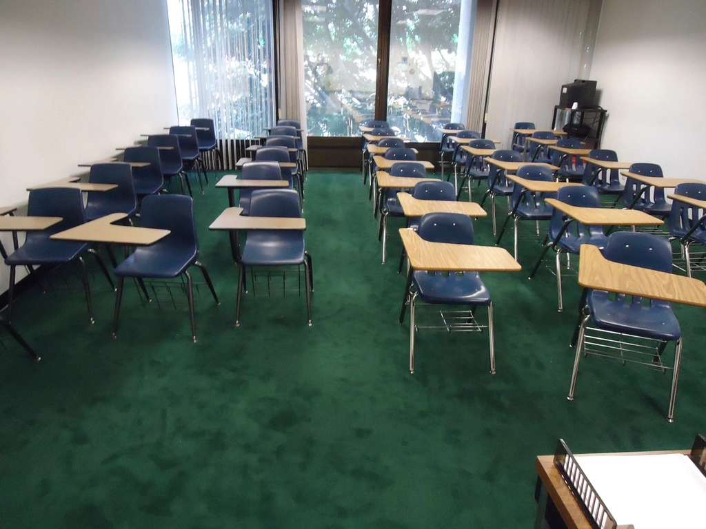 Rows of empty school desks in a classroom